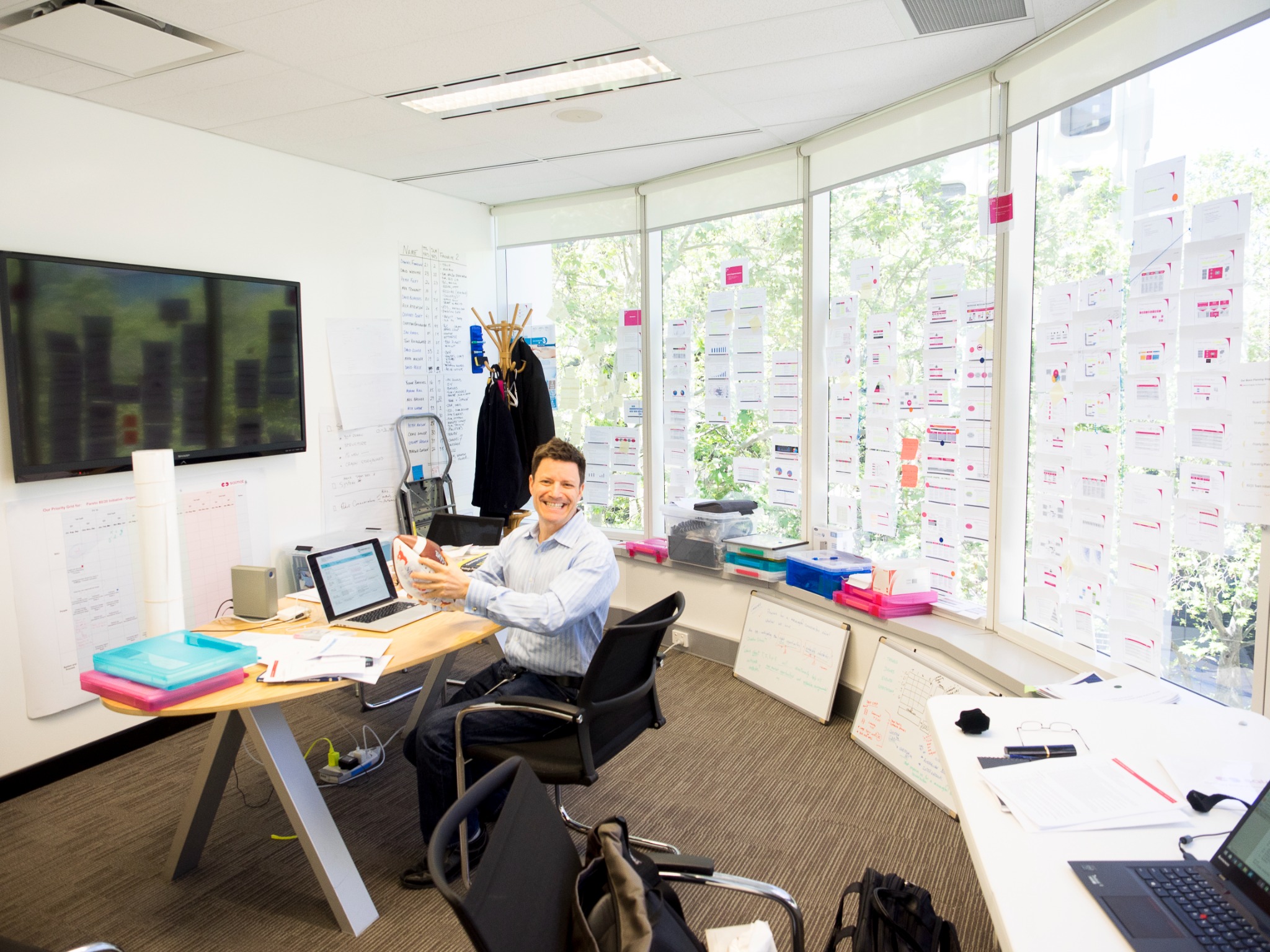 James working in a room surrounded by visible planning, priorities and practical decision-support materials