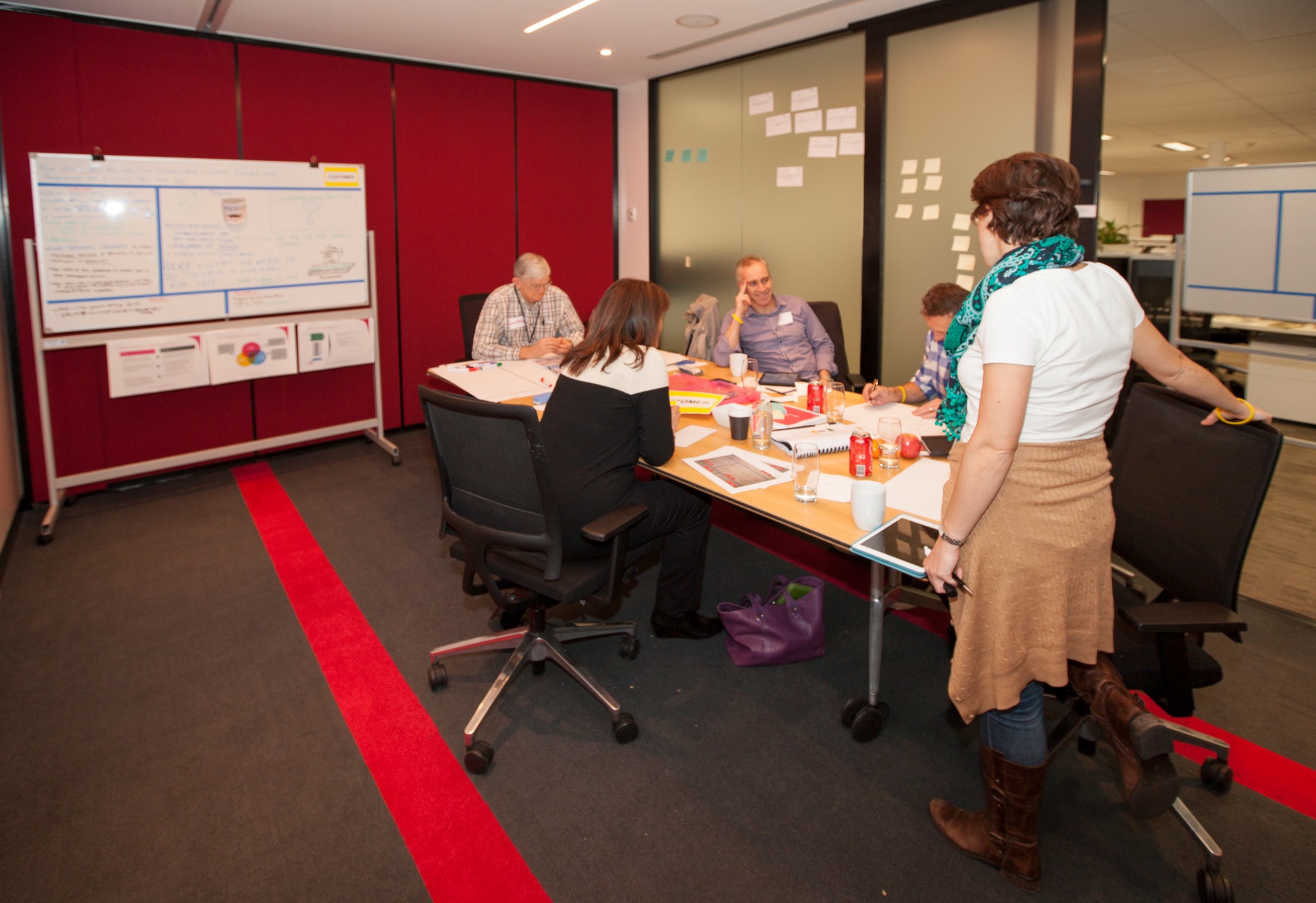 A small cross-functional Salmat team constructing an answer around a working table and board